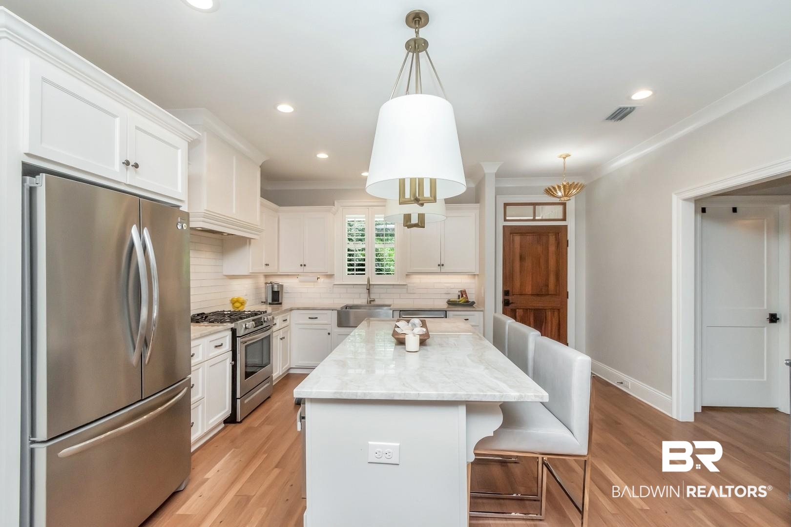 4404 Stein Street Mobile, AL 36608 - Photo 13 of 50 Kitchen with appliances with stainless steel finishes, backsplash, white cabinets, a breakfast bar area, and a kitchen island