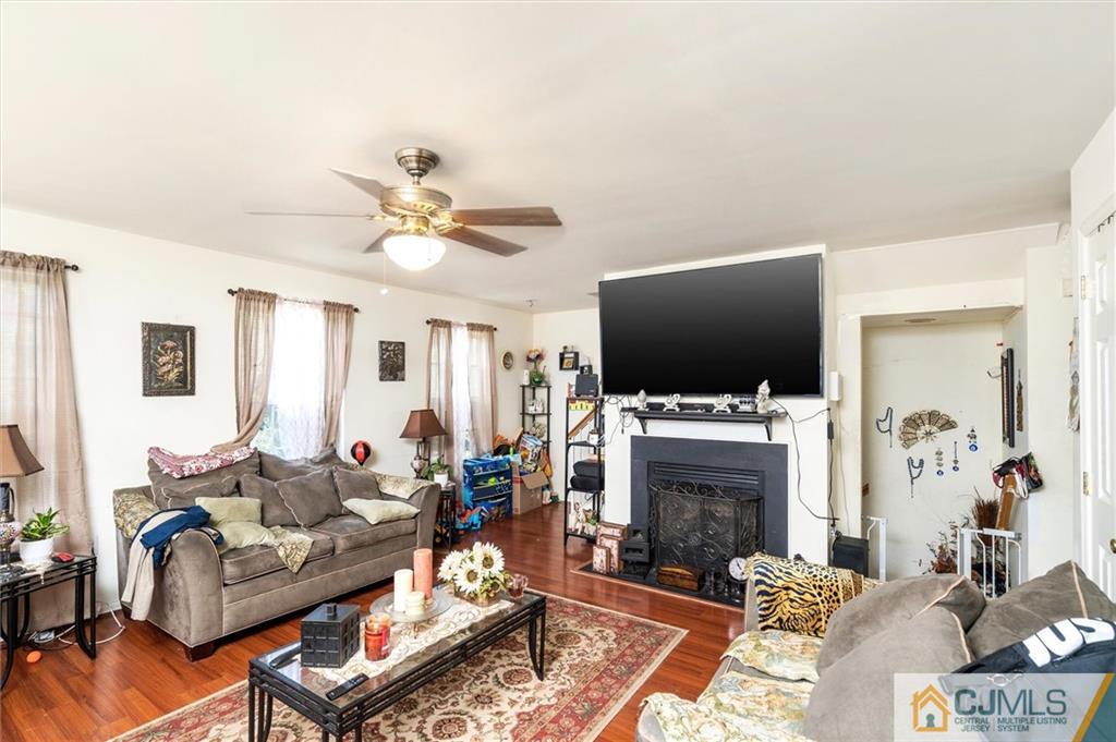 35 Rojewski Way Sayreville, NJ 08859 - Photo 13 of 23 a living room with furniture a flat screen tv and a fireplace