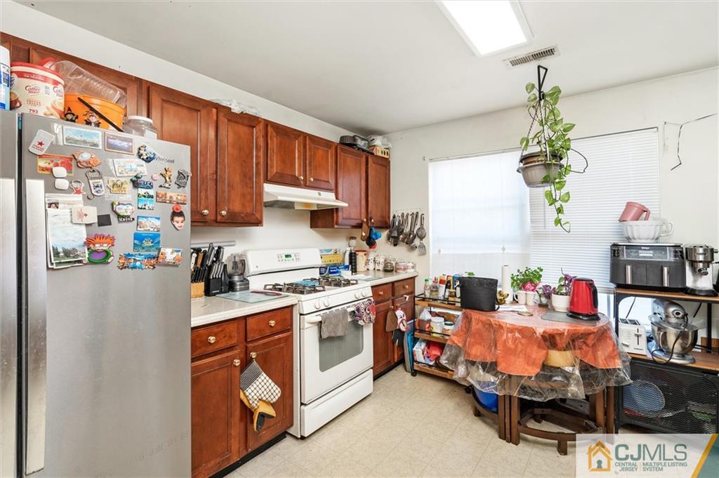 35 Rojewski Way Sayreville, NJ 08859 - Photo 4 of 23 a kitchen with stainless steel appliances a stove a refrigerator a sink and a cabinets