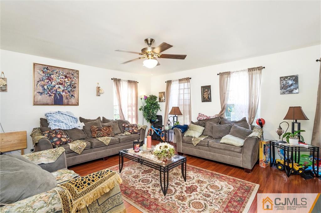 35 Rojewski Way Sayreville, NJ 08859 - Photo 8 of 23 a living room with furniture a rug and a chandelier