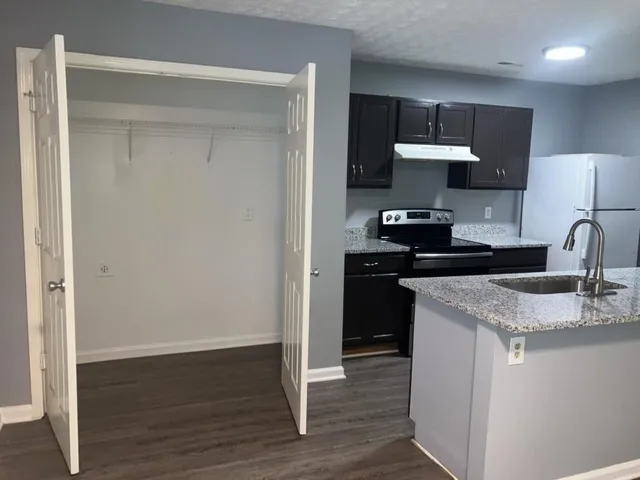 a kitchen with stainless steel appliances a sink and wooden floor