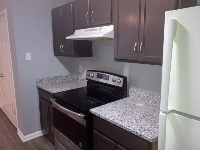 a kitchen with granite countertop stainless steel appliances and wooden cabinets