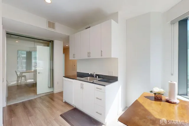 a kitchen with granite countertop a sink a stove and cabinets