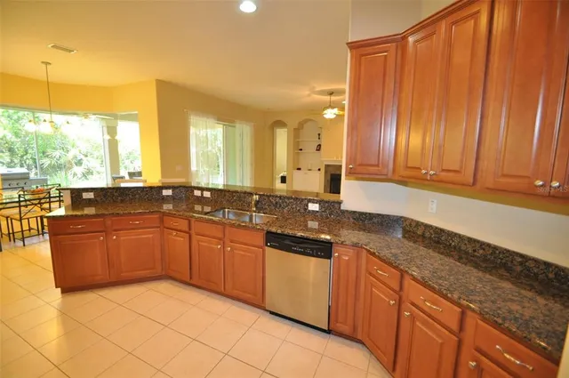 a large kitchen with kitchen island granite countertop a sink window and cabinets