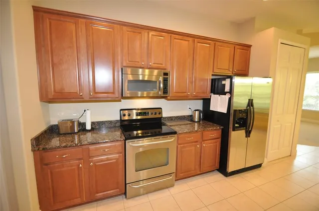 a kitchen with stainless steel appliances granite countertop a stove a sink and a microwave