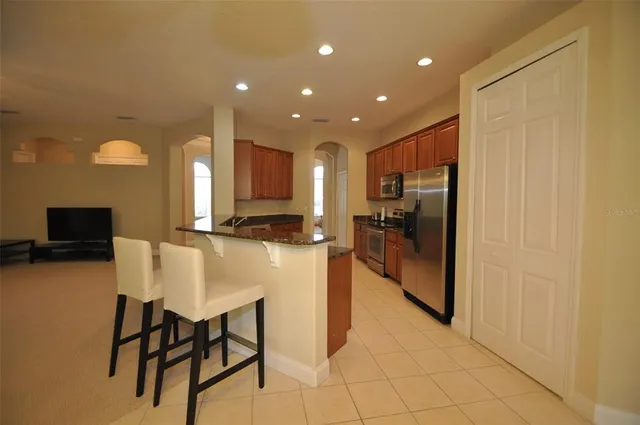 a kitchen with stainless steel appliances granite countertop a refrigerator and a stove top oven