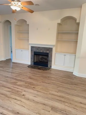 a view of empty room with wooden floor and fireplace