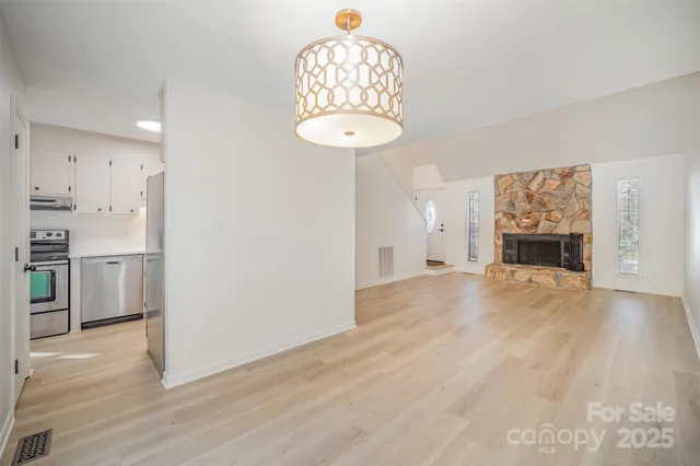 a view of a room with wooden floor and kitchen