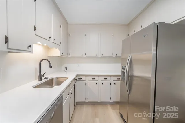 a kitchen with stainless steel appliances a refrigerator sink and cabinets
