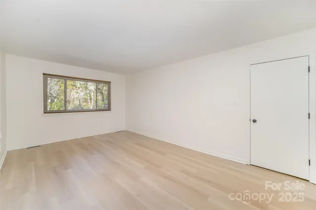 an empty room with windows and closet