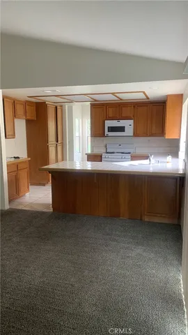a living room with stainless steel appliances wooden floor and a large window