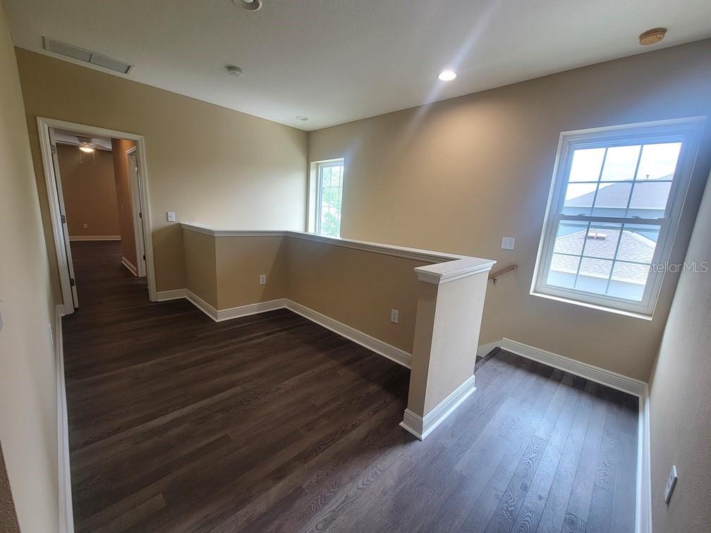 10418 Fenceline Road New Port Richey, FL 34655 - Photo 18 of 36 an empty room with wooden floor and windows