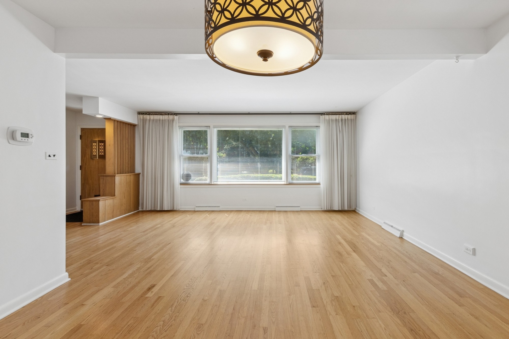 9007 Forestview Road Evanston, IL 60203 - Photo 6 of 29 a view of an empty room with wooden floor and a window
