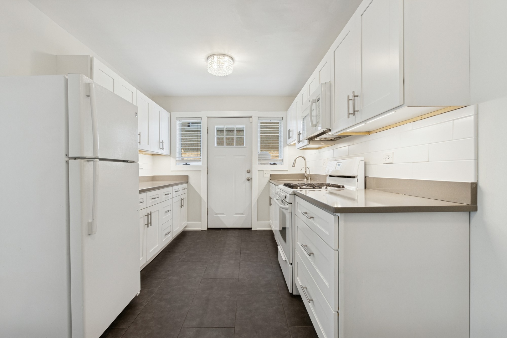 9007 Forestview Road Evanston, IL 60203 - Photo 10 of 29 a kitchen with white cabinets and white appliances