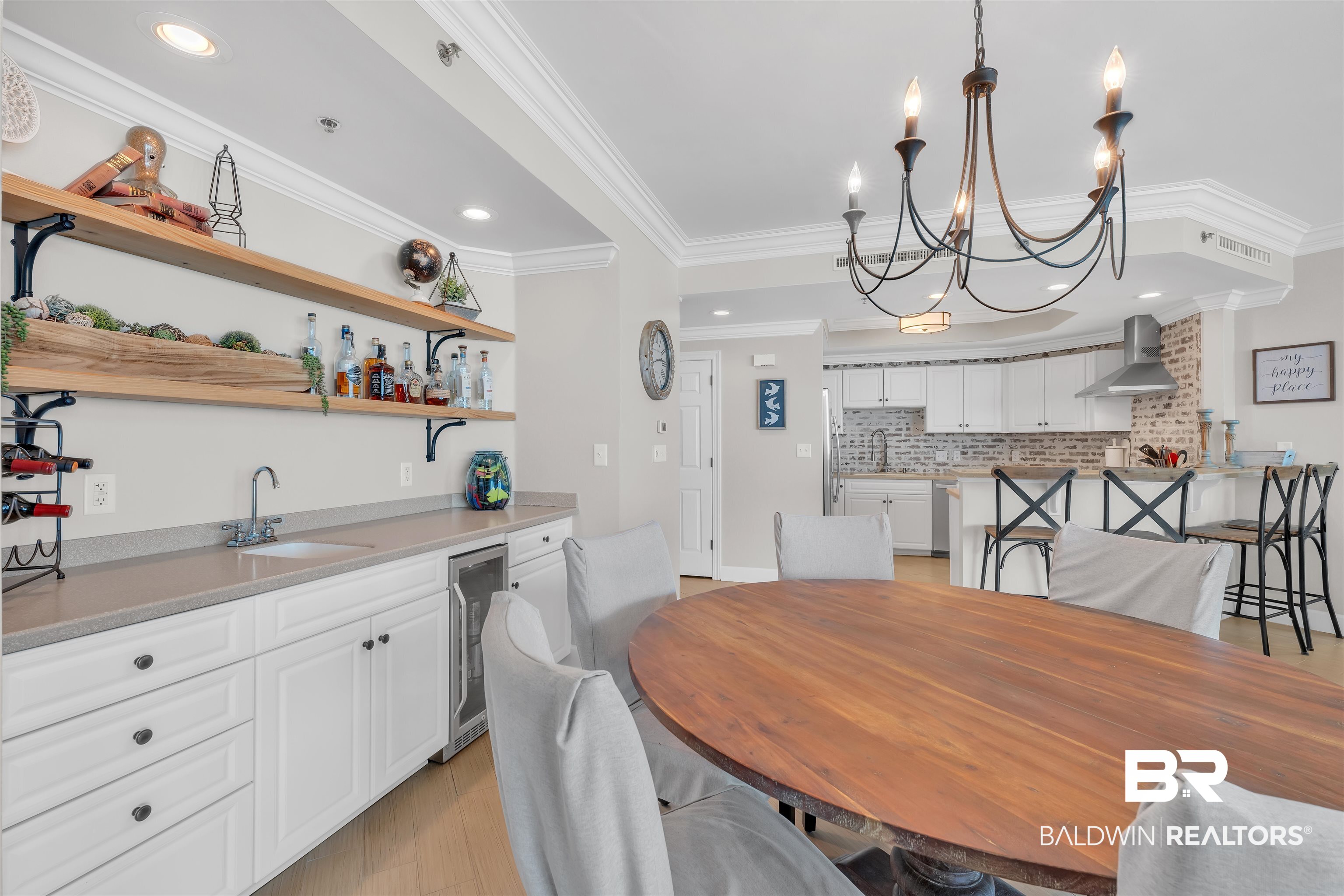 27582 Canal Road, Unit 2605 Orange Beach, AL 36561 - Photo 9 of 41 Dining room with beverage cooler, wet bar, a chandelier, crown molding, and light wood-style floors