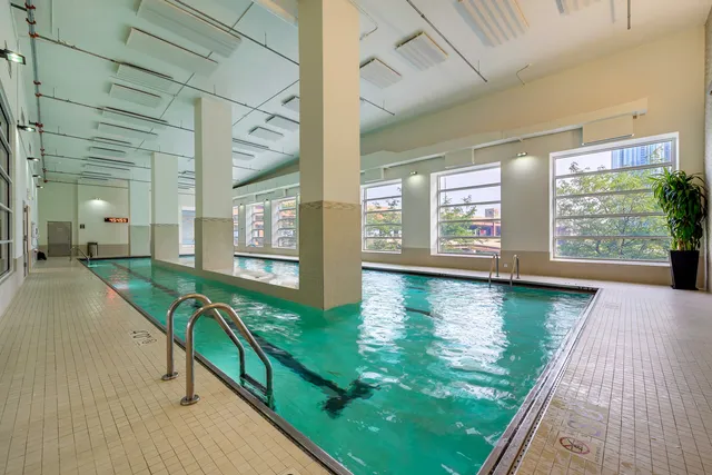 a view of swimming pool with a large window and wooden floor