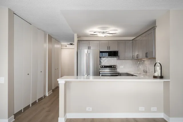 a kitchen with stainless steel appliances granite countertop a sink refrigerator and cabinets
