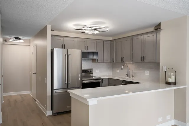 a kitchen with a refrigerator a sink and cabinets