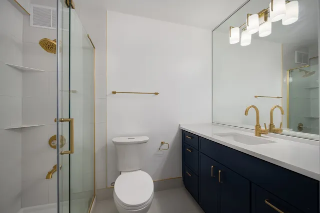 a bathroom with a double vanity sink toilet and shower