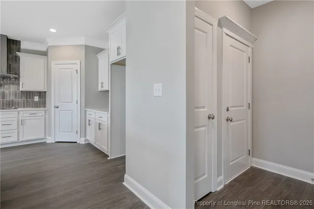 a view of a hallway with wooden floor and closet area