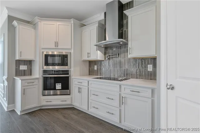 a kitchen with white cabinets and appliances
