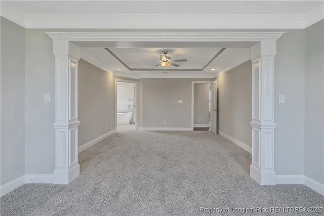 an empty room with windows and ceiling fan
