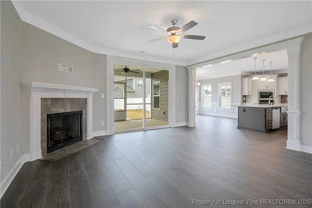 a view of a livingroom with a fireplace a chandelier and wooden floor