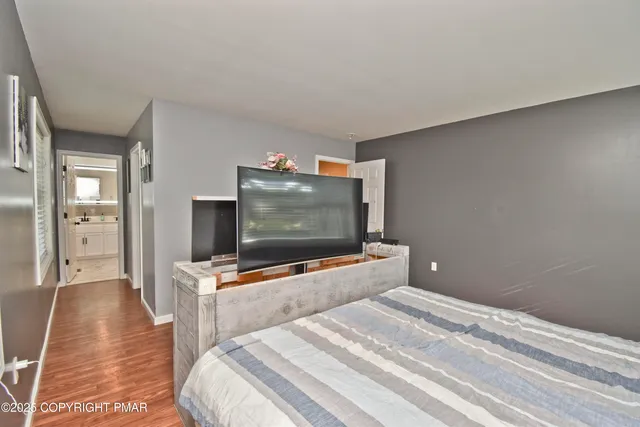 a bedroom with a bed and flat screen tv