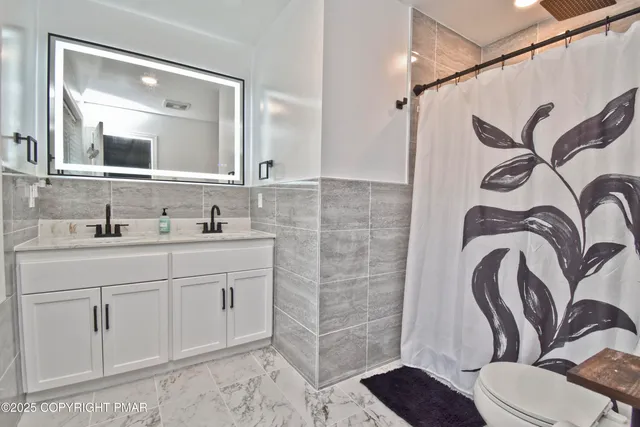 a bathroom with a granite countertop sink a toilet and a mirror