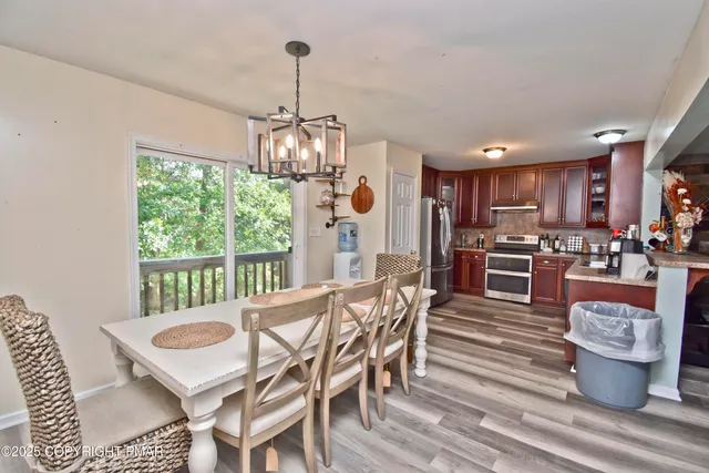 a view of a dining room and livingroom with furniture wooden floor a chandelier