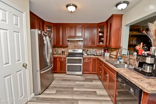 a kitchen with granite countertop stainless steel appliances and wooden cabinets