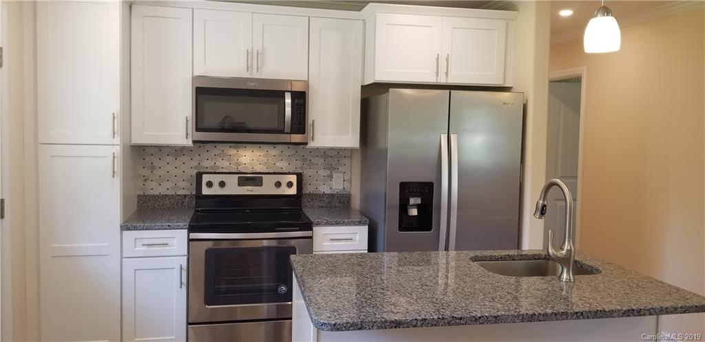4226 Colebrook Road Charlotte, NC 28215 - Photo 3 of 11 a kitchen with a refrigerator stove and cabinets