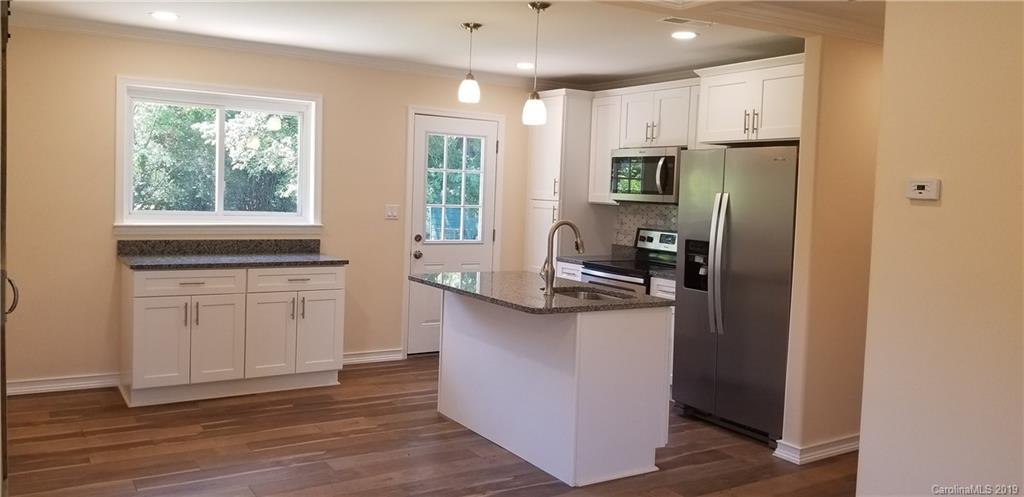 4226 Colebrook Road Charlotte, NC 28215 - Photo 4 of 11 a kitchen with stainless steel appliances granite countertop a refrigerator a sink dishwasher a stove and white countertops with wooden floor