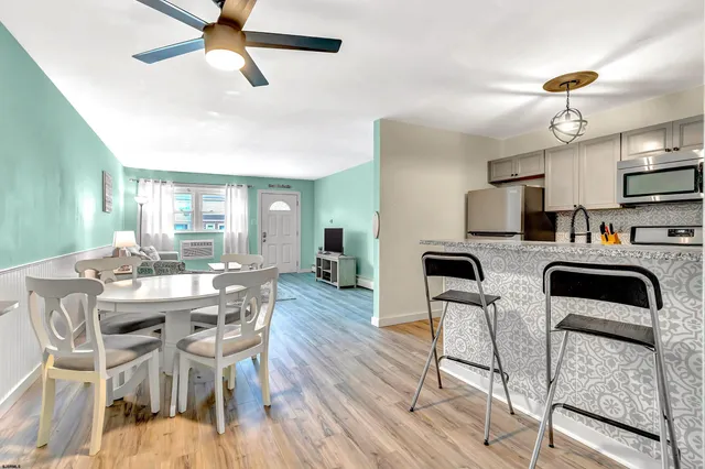 a view of a dining room with furniture and a kitchen