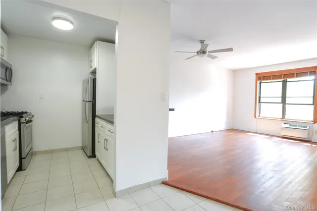 an empty room with windows and cabinet