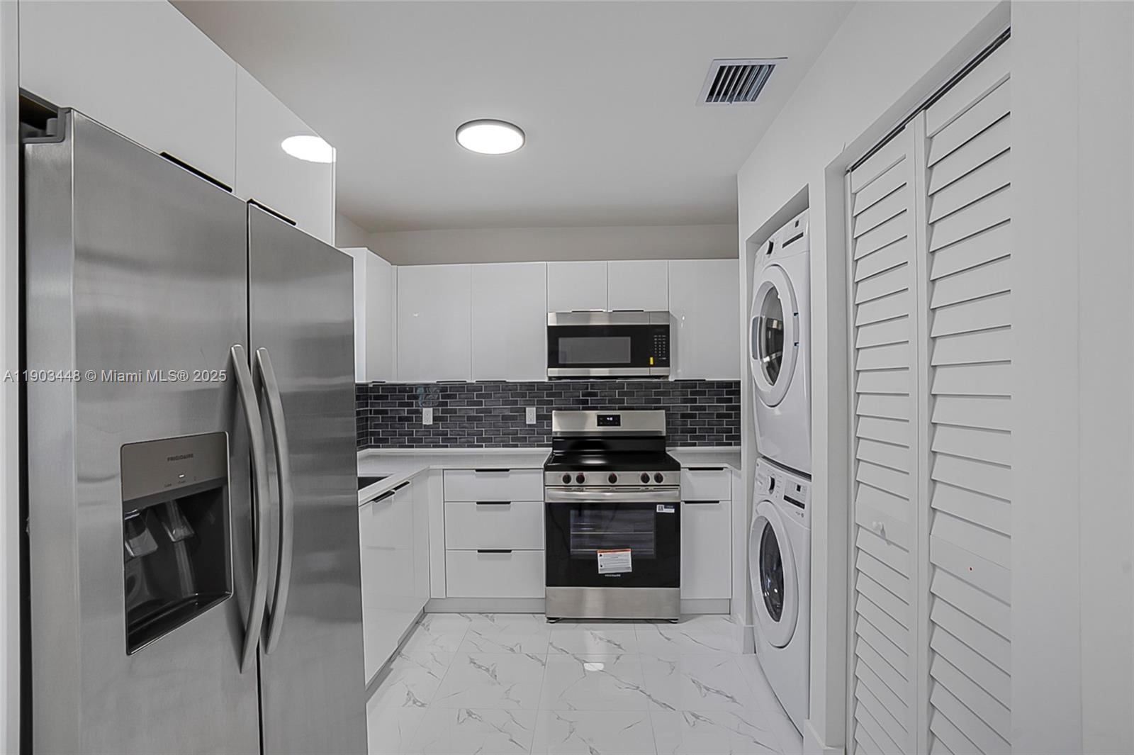 10362 Southwest 180th Street, Unit 3 Miami, FL 33157 - Photo 4 of 17 a kitchen with stainless steel appliances a refrigerator stove and microwave