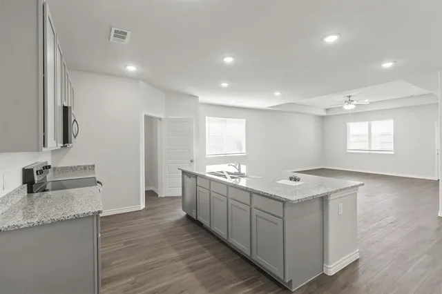 a kitchen with stainless steel appliances granite countertop a sink and a stove top oven