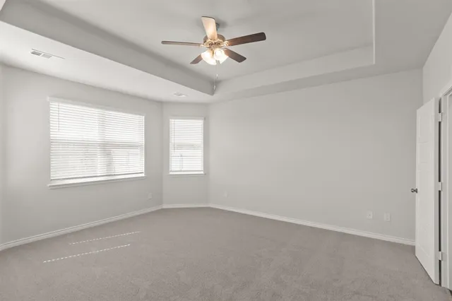 an empty room with a window and a ceiling fan