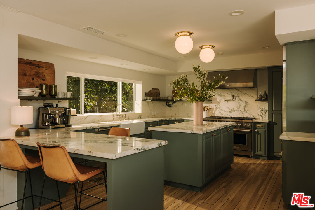 2610 Mandeville Canyon Road Los Angeles, CA 90049 - Photo 13 of 32 a kitchen with counter top space appliances and cabinets