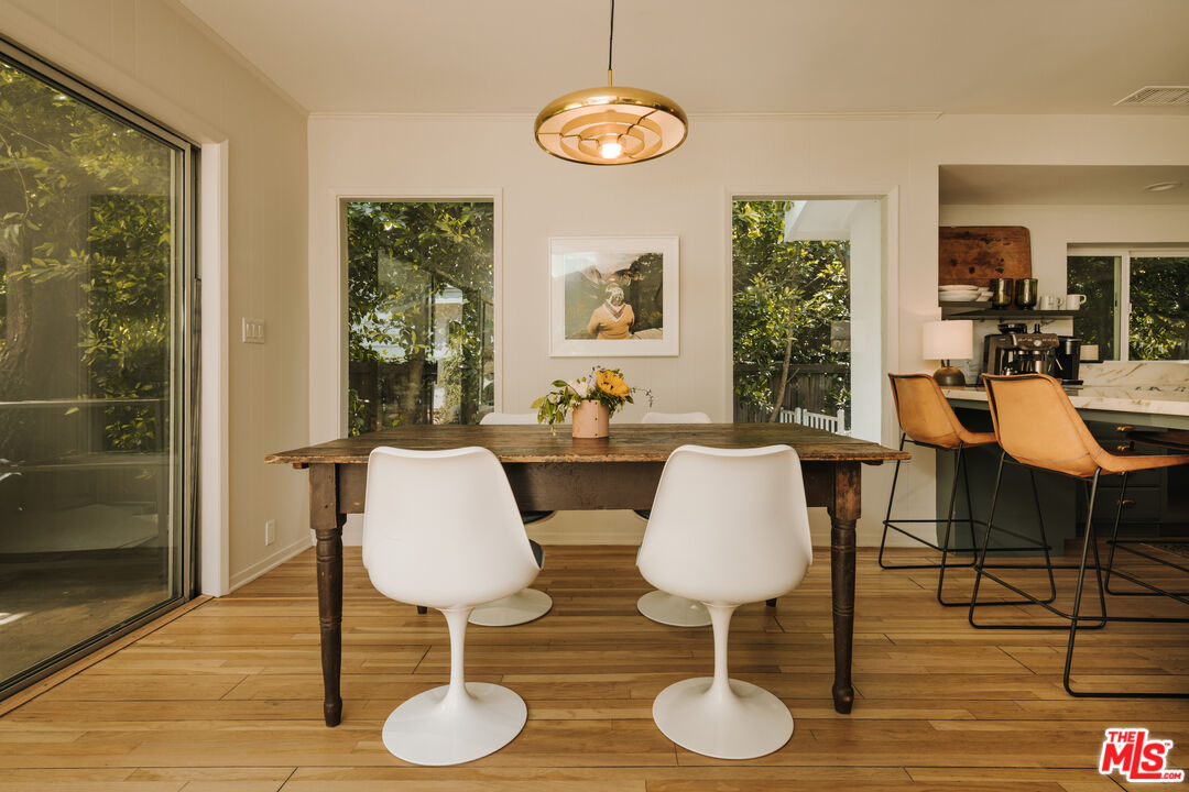 2610 Mandeville Canyon Road Los Angeles, CA 90049 - Photo 16 of 32 a view of a dining room with furniture and wooden floor