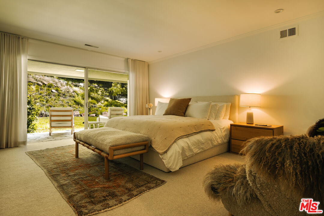 2610 Mandeville Canyon Road Los Angeles, CA 90049 - Photo 21 of 32 a spacious bedroom with a bed and glass walk in closet