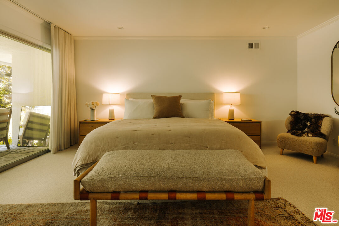 2610 Mandeville Canyon Road Los Angeles, CA 90049 - Photo 22 of 32 a bedroom with a bed and wooden floor