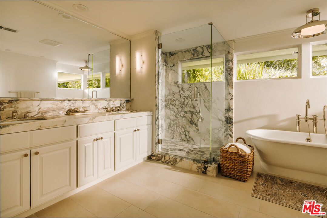 2610 Mandeville Canyon Road Los Angeles, CA 90049 - Photo 24 of 32 a bathroom with a tub sink and mirror