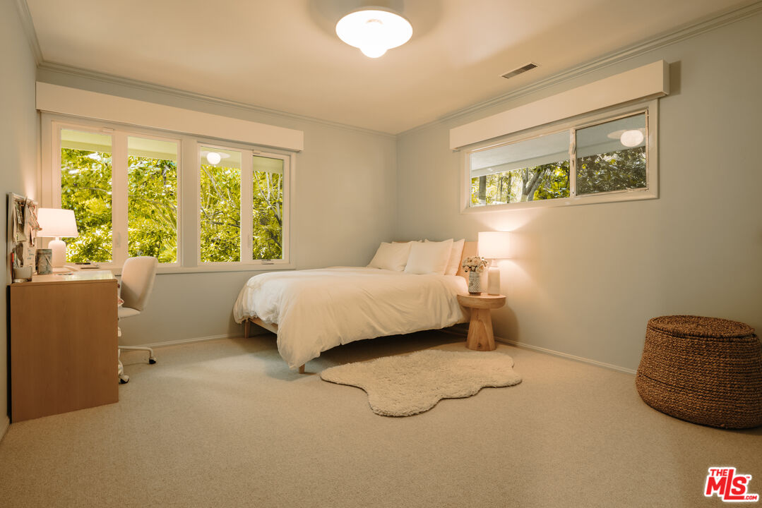 2610 Mandeville Canyon Road Los Angeles, CA 90049 - Photo 25 of 32 a bedroom with a bed and a lamp next to a window