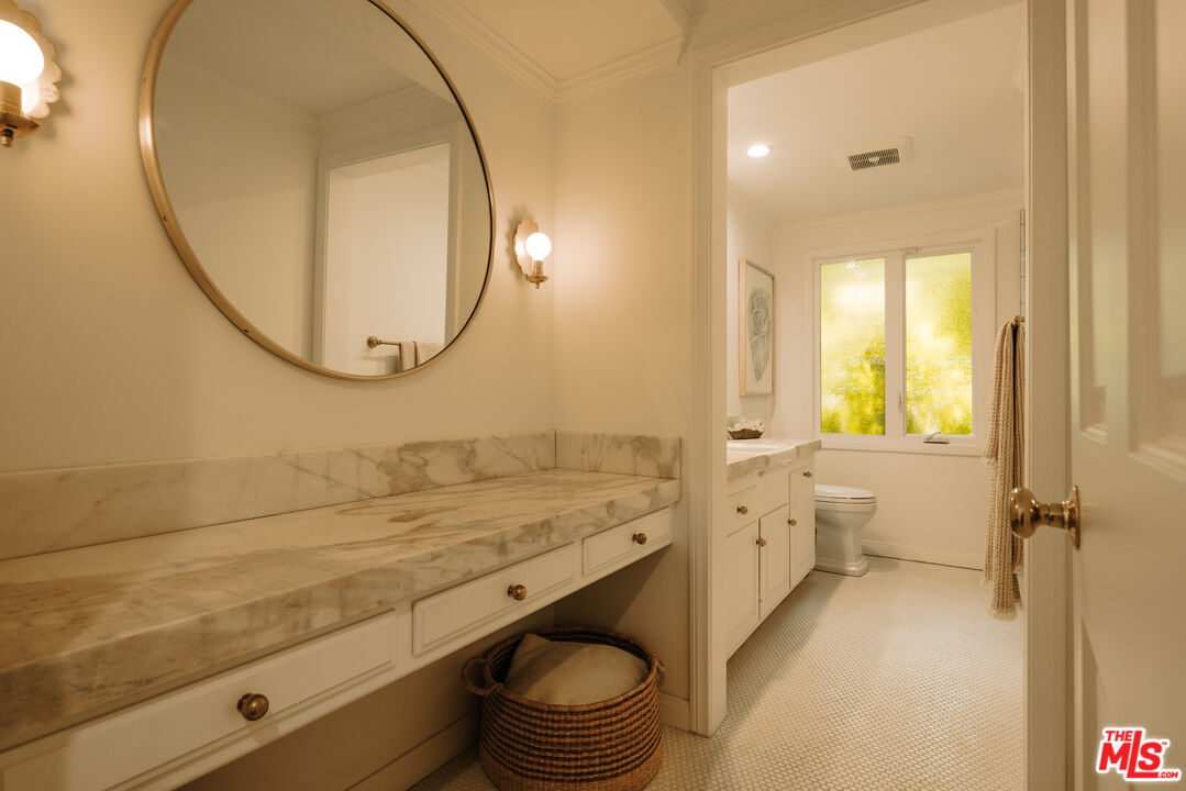 2610 Mandeville Canyon Road Los Angeles, CA 90049 - Photo 26 of 32 a bathroom with a sink a toilet and a mirror