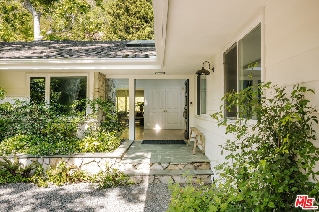 2610 Mandeville Canyon Road Los Angeles, CA 90049 - Photo 3 of 32 front view of a house with a yard