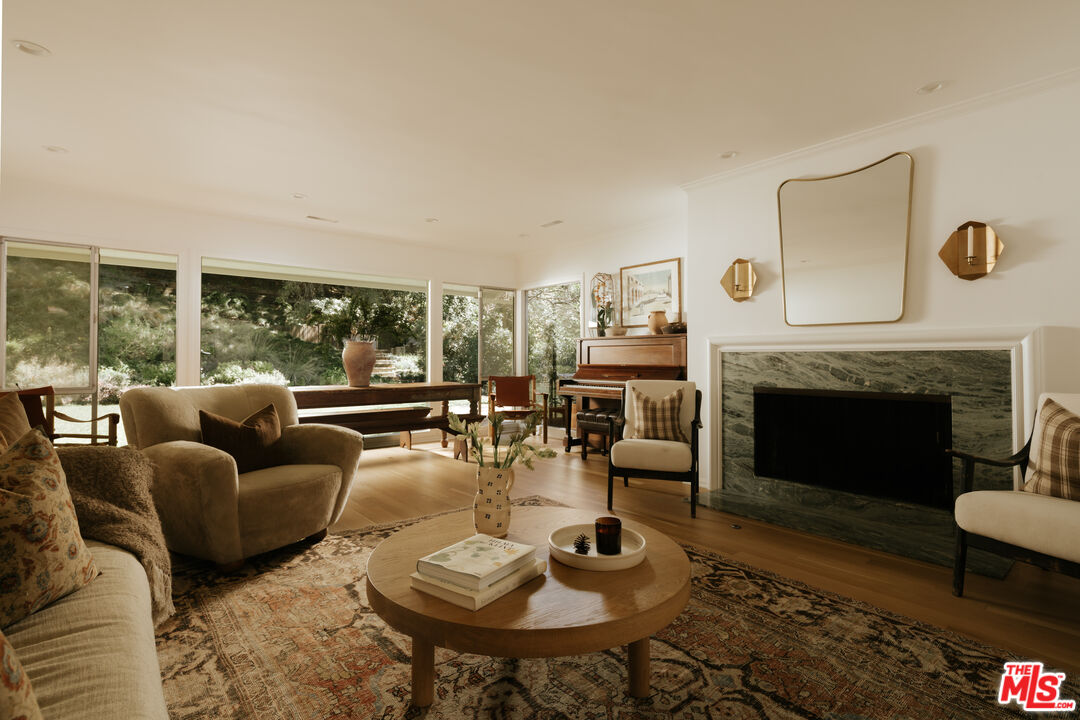 2610 Mandeville Canyon Road Los Angeles, CA 90049 - Photo 5 of 32 a living room with furniture a large window and a fireplace
