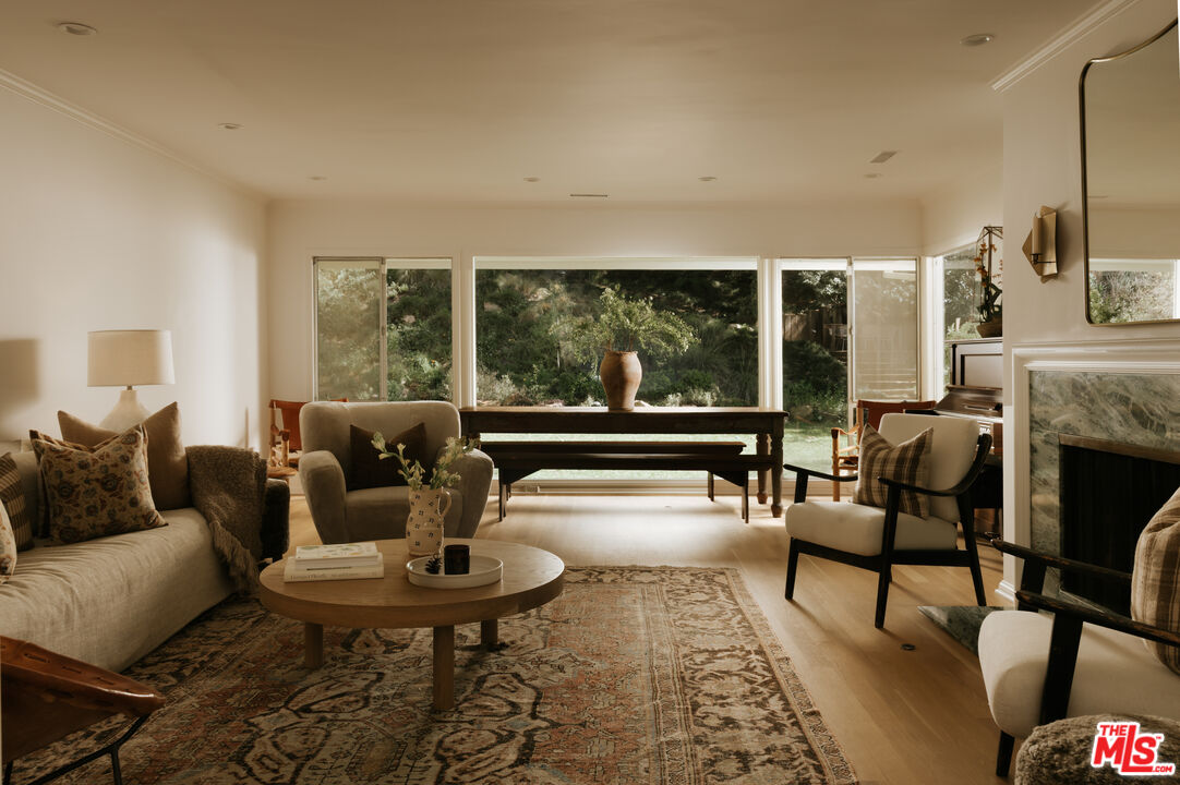 2610 Mandeville Canyon Road Los Angeles, CA 90049 - Photo 8 of 32 a living room with fireplace furniture and a large window