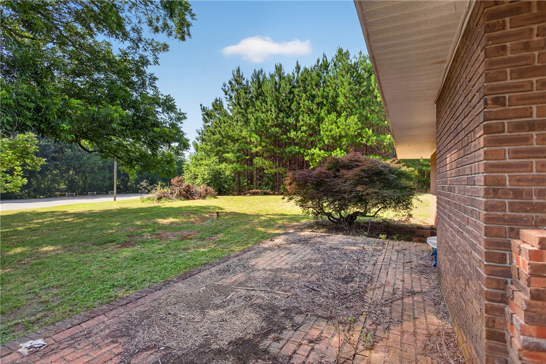 1412 Simpson Road Pendleton, SC 29670 - Photo 48 of 48 A well-maintained brick exterior opens to a spacious, verdant yard with mature trees providing ample shade.