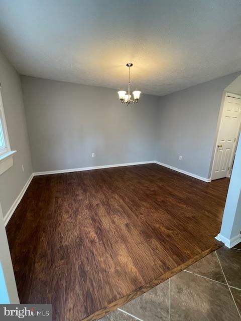 48 Fleming Street Newark, DE 19713 - Photo 6 of 16 an empty room with wooden floor and chandelier